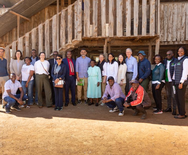 The visiting team posing for a group photo with the farmer and her family.